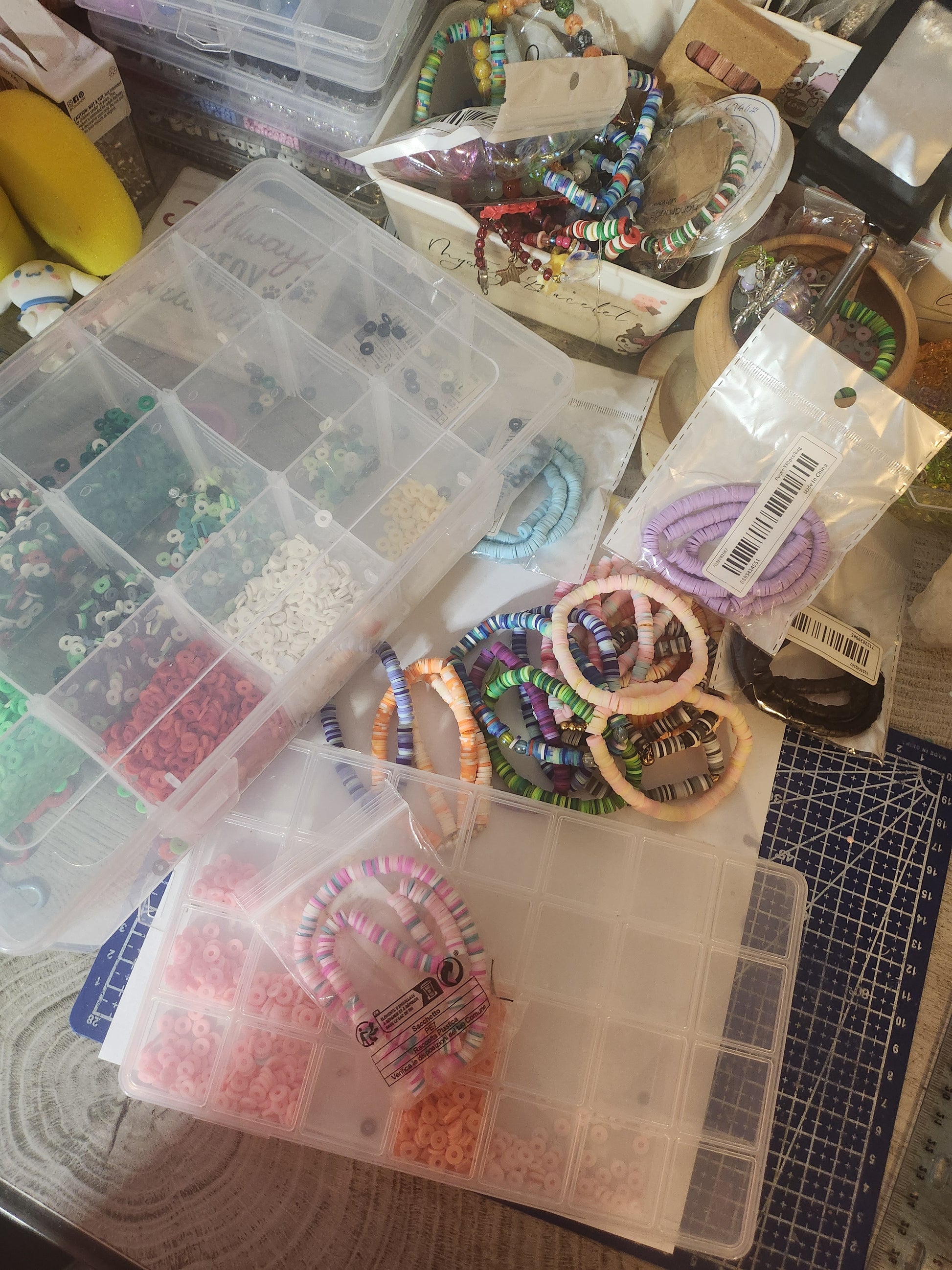 Assorted beads and jewelry-making supplies on a table with a cutting mat.